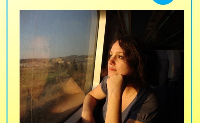 Виктория мечтательно смотрит в окно поезда